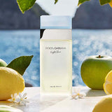 Dolce Gabbana Light blue perfume bottle with ingredients of apple lemon and jasmien with a seaside backdrop